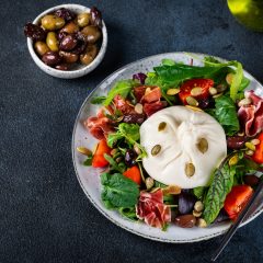 Burrata salad with tomatoes and salad mix. Healthy eating concept. Keto diet salad
